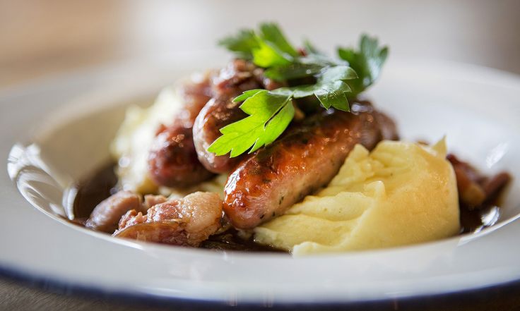 a white plate topped with meat and potatoes