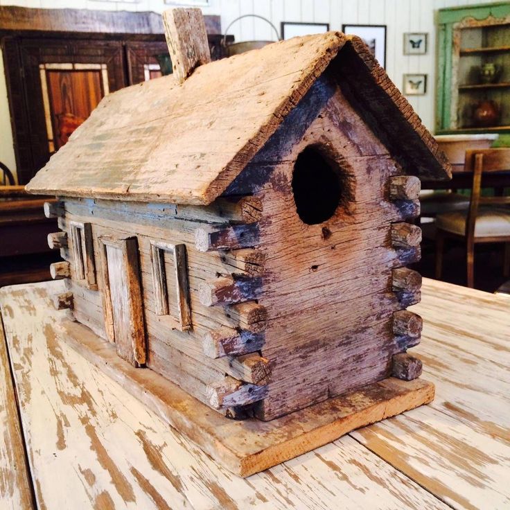 a wooden birdhouse sitting on top of a table