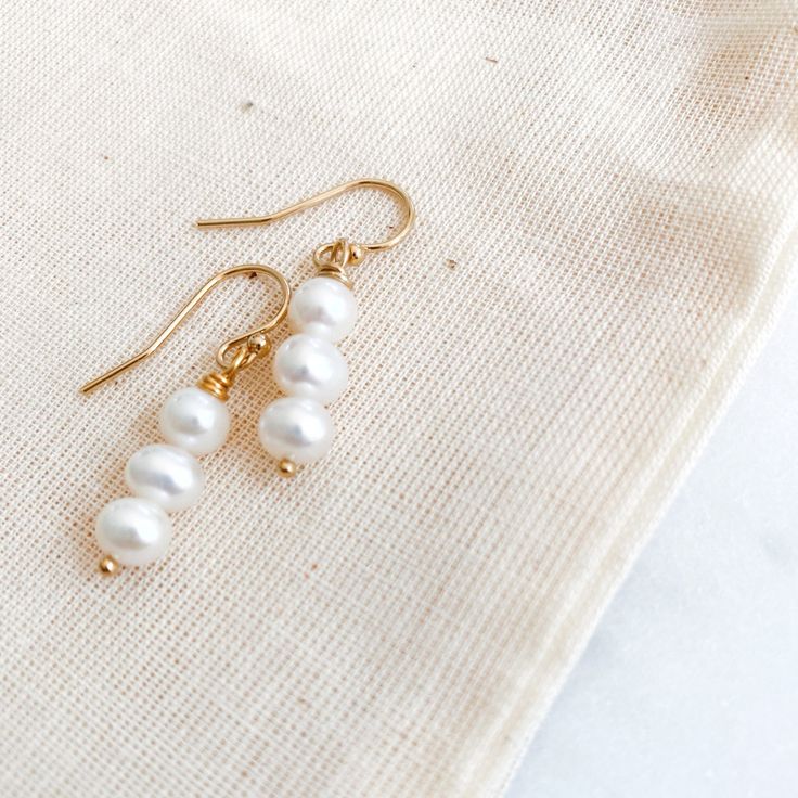 Drops of luminous ivory pearls. Available in 14k gold-filled or sterling silver. Delicate Pearl White Pearl Drop Earrings, White Gold-plated Dangle Pearl Earrings, White Gold Plated Dangle Pearl Earrings, 14k Gold Filled Pearl Chain Jewelry For Anniversary, White Gold Plated Jewelry With Ear Wire, Everyday White Pearl Earrings, Dainty White Pearl Earrings, Pearl White Drop Pearl Earrings In 14k Gold Filled, Pearl White 14k Gold Filled Drop Earrings