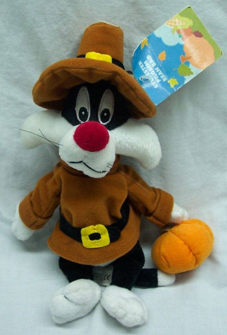 a stuffed animal with a book on it's head and an orange ball in its hand