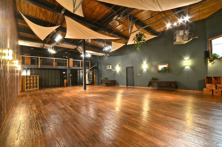 an empty room with wooden floors and lights