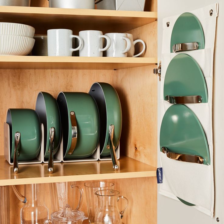 green dishes are stacked on top of each other in front of a wall mounted dish rack