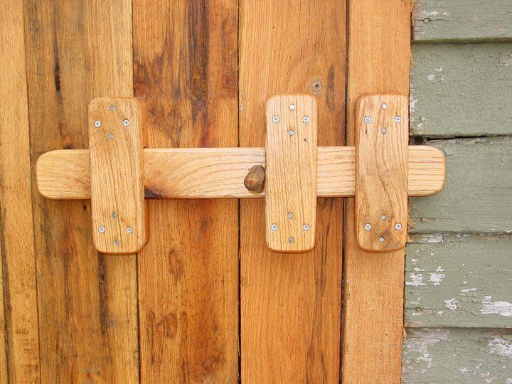 a close up of a wooden door handle on a wood paneled wall with a red frame