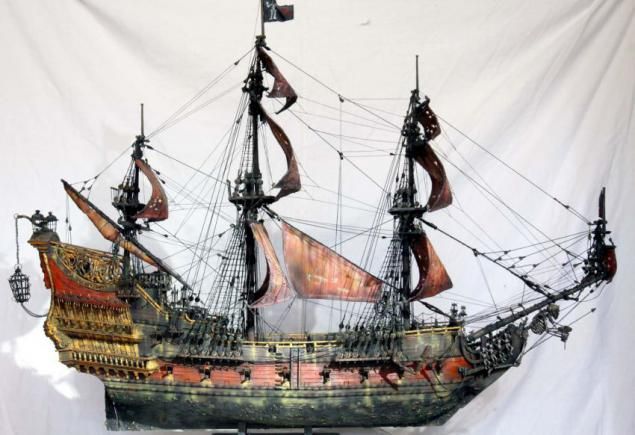 a model pirate ship is on display against a white backdrop