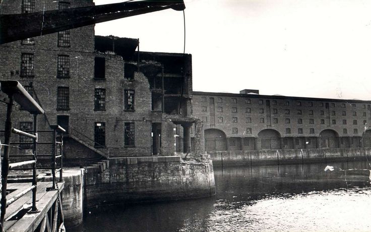 a black and white photo of an old building next to a body of water