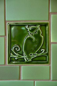 a green tile with an owl on it