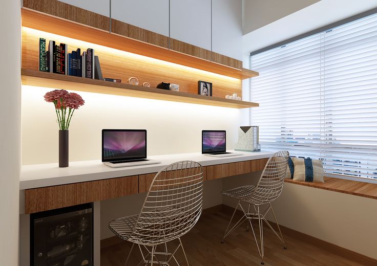 a desk with two laptops on it in front of a window and bookshelf