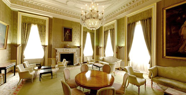 an elegant living room with chandelier and paintings on the walls