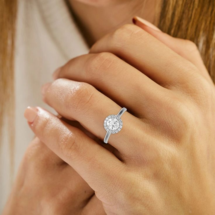 a woman's hand with a diamond ring on it