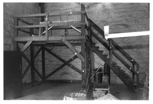 an old black and white photo of stairs in a stone walled building with metal railings