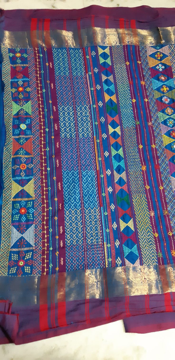 a blue and red cloth with designs on it sitting on top of a white surface