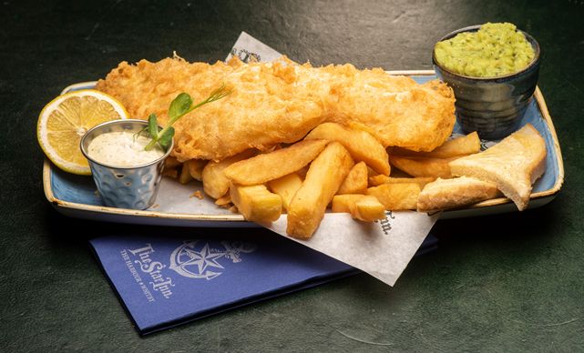 fish and chips are served on a blue plate