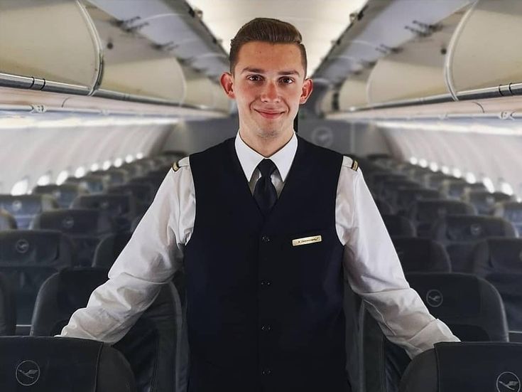 a man standing in an airplane with his hands on his hips