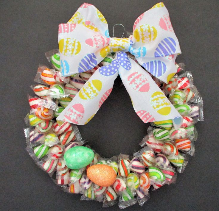 an easter wreath made out of candy wrapped in cellophane and tied with a bow