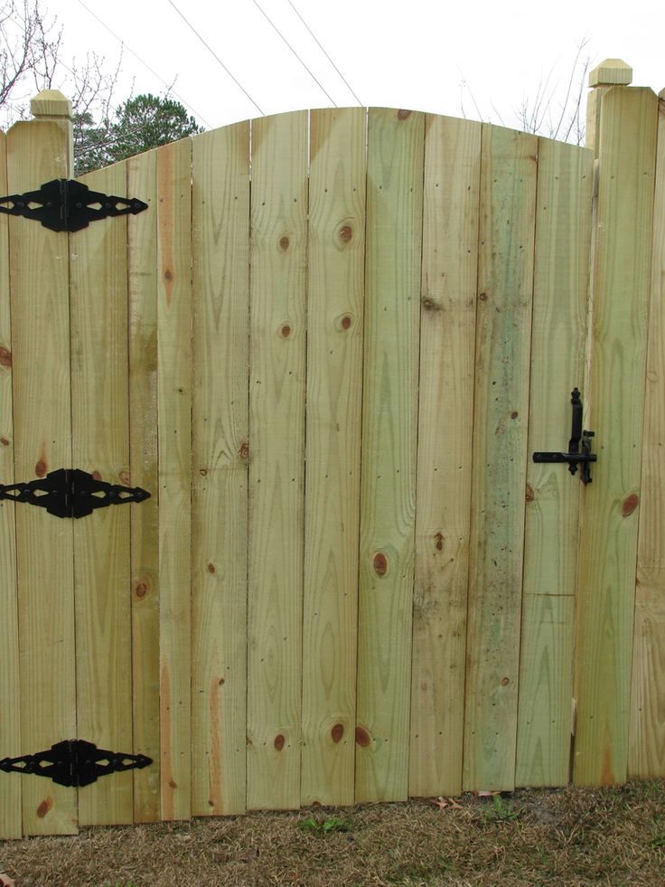 a wooden fence with black iron hardware on it