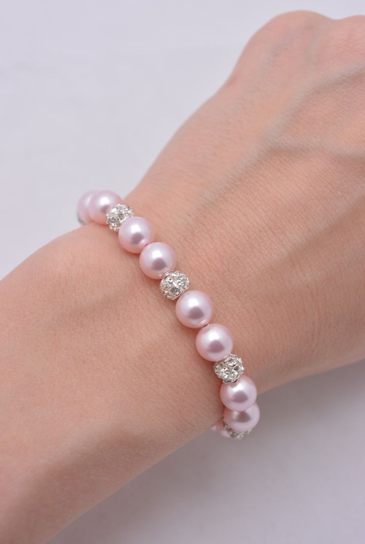 LISTING IS FOR ALL 5 LIGHT PINK PEARL BRACELETS This set of 5 bracelets is hand-crafted using light pink Swarovski pearls and silver plated rhinestones. Approximately 6 1/2 inches at shortest length with silver plated extension chain for an adjustable fit up to 8 inches. Each comes in a gift box, perfect for gift-giving! Standard fits sizes between 6.5-8 inches. Pearl available in white, ivory, light pink, light grey and dark grey - just add note at checkout (standard is light pink). SHIPPING: T Pink Crystal Wedding Bracelets, Pink Sparkling Stones Bracelet For Wedding, Pink Wedding Bracelets With Sparkling Stones, Pink Crystal Beaded Round Bracelets, Elegant Pink Bracelets For Party, Elegant Pink Round Beaded Bracelets, Pink Rhinestone Round Bead Jewelry, Formal Pink Crystal Bracelet, Pink Crystal Bracelets For Formal Occasions