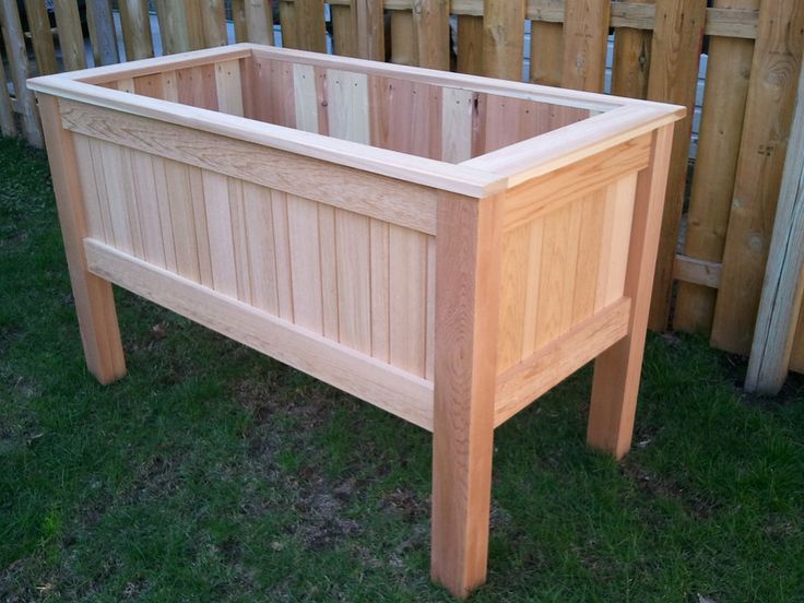 a wooden planter box sitting in the grass