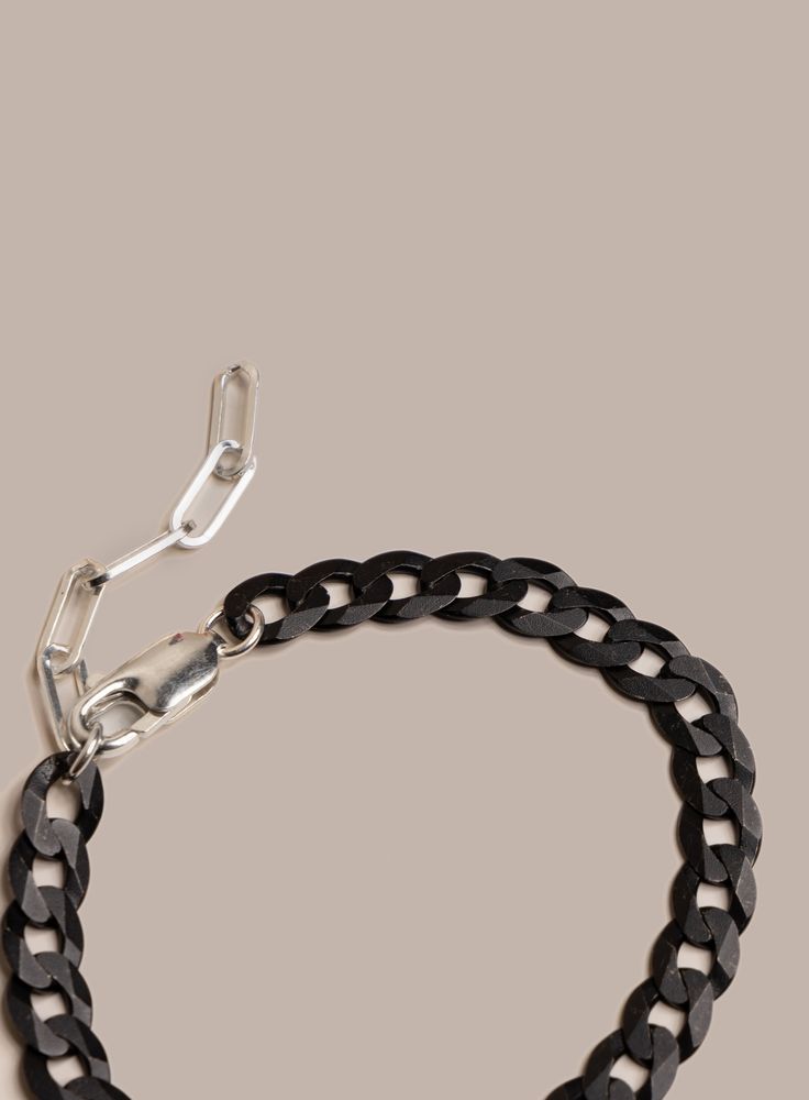 We love this super unique chain link. Starting up with the ultra wide, ultra flat cuban link and then elevated with the Titanium Coating. Add to that the contrast of the 925 Sterling Silver clasp and extender and you end up with a futuristic yet modern unique chain bracelet. Add this to the "for the man who has it all" collection. Chain Links: 8mm Material: Titanium Coated over Sterling Silver. Note the titanium will reveal specks of the silver underneath. It is the intended look to reveal an ef Modern Cuban Link Bracelet With Chunky Chain, Modern Chunky Cuban Link Bracelet, Modern Cuban Link Chain Bracelet With Solid Construction, Modern Chunky Chain Cuban Link Bracelets, Modern Bracelets With Chunky Cuban Link Chain, Modern Chunky Cuban Link Chain Bracelet, Modern Sterling Silver Bracelet With Chunky Chain, Modern Chunky Chain Cuban Link Bracelet, Modern Cuban Link Bracelet With Silver Chain