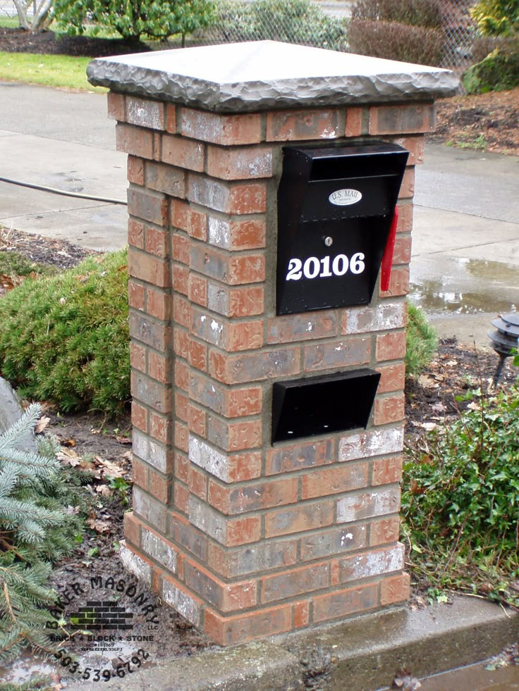 a brick mailbox sitting on the side of a road