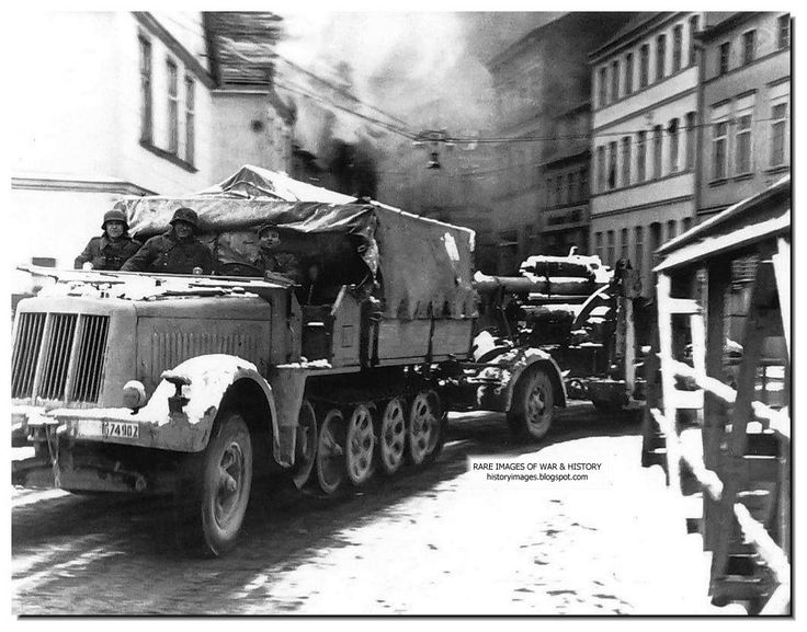 A German Heavy half-track tractor tows a Sd.Kfz.7 88-mm anti-aircraft ...