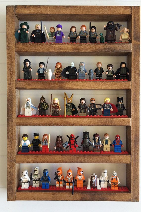 a shelf filled with lego minifigures on top of red shelves next to a white wall