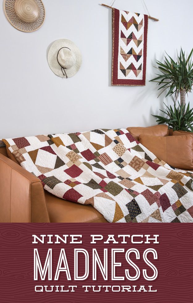 a couch with a quilt on it in front of a wall