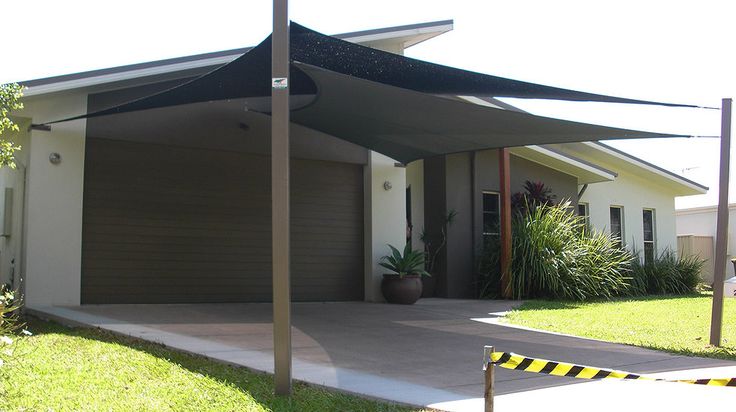 a house with a car parked in front of it and an awning over the driveway