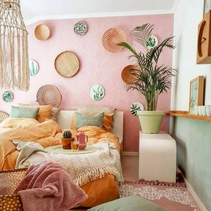 a bedroom with pink walls and lots of pillows on the floor, plants in vases