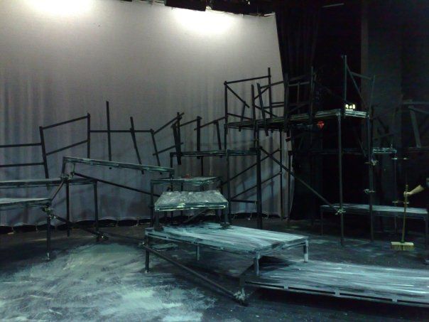 an empty stage with several chairs and scaffolding