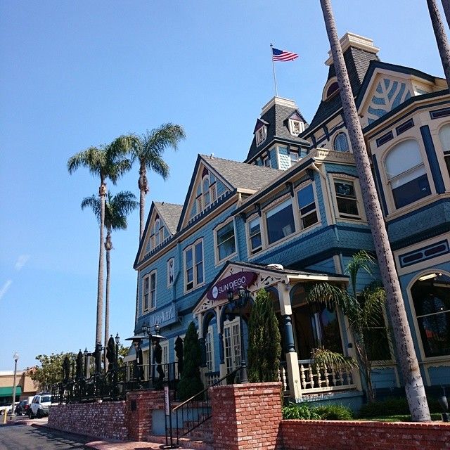 a large blue building sitting on the side of a road next to tall palm trees