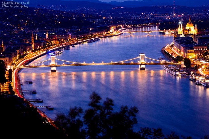 an aerial view of a city at night, with the lights on and bridges lit up