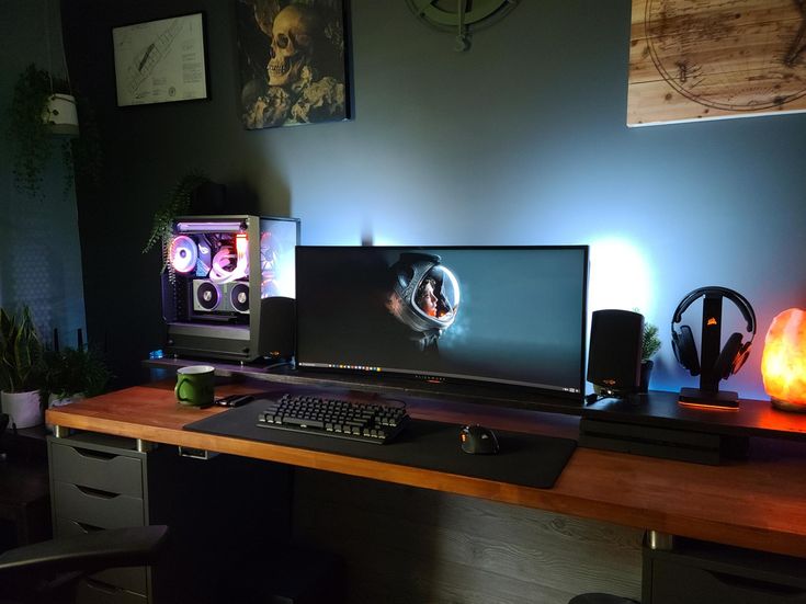 two computer monitors sitting on top of a wooden desk