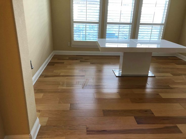 an empty room with wooden floors and windows