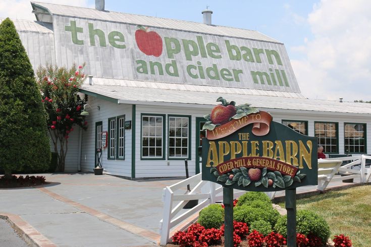 the apple barn and cider mill is located in front of a white building with green trim