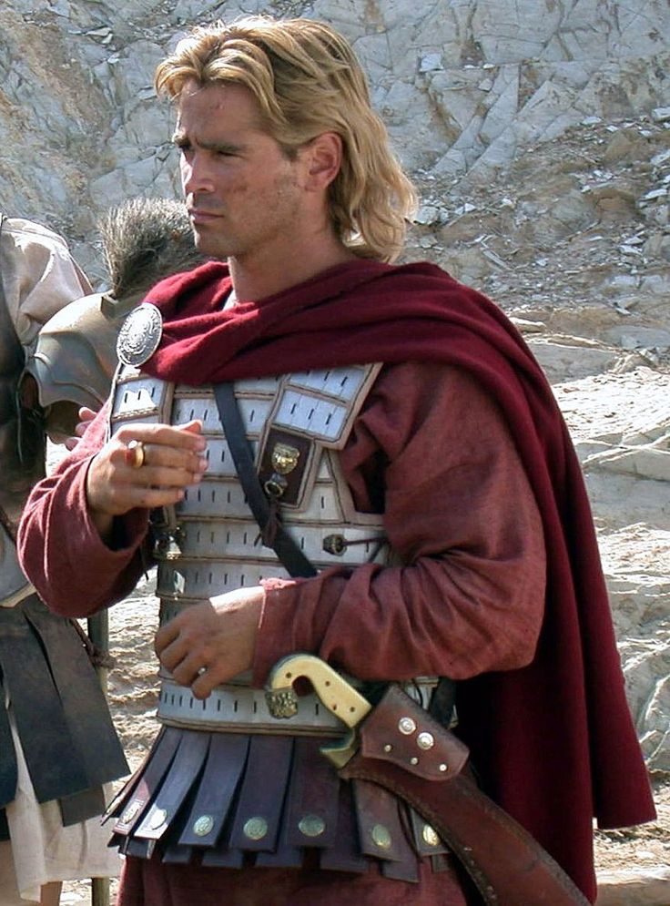 a man dressed in roman armor and holding a microphone while standing next to another man