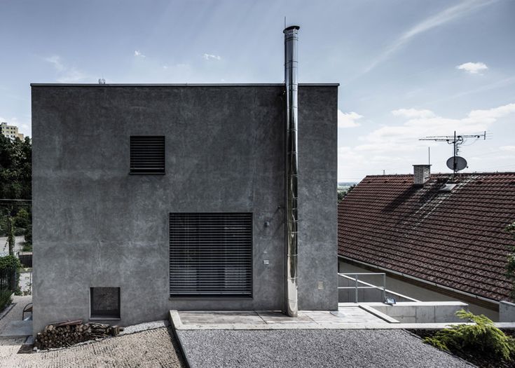 an exterior view of a concrete building with shutters on the windows and stairs leading up to it