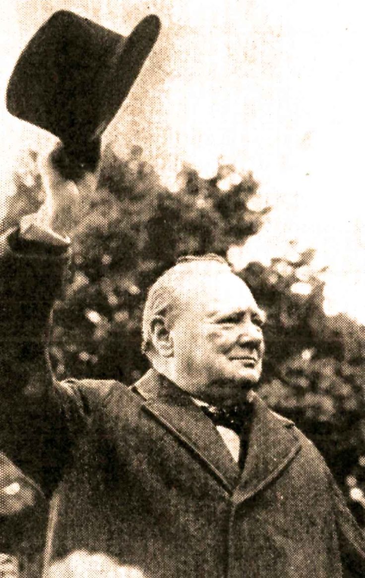 an old black and white photo of a man holding a hat up in the air