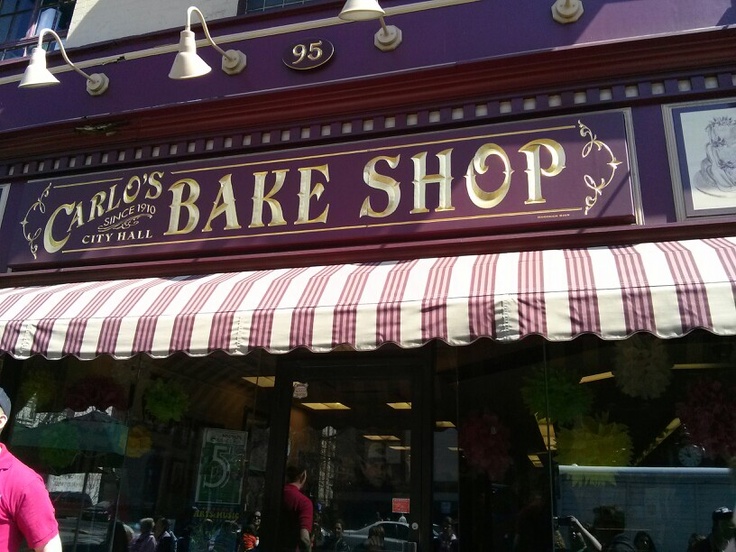 there is a man standing in front of the bakery shop that sells cakes and pies