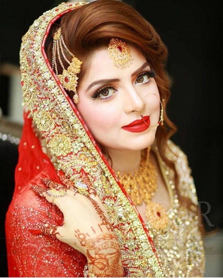 a woman wearing a red and gold bridal outfit