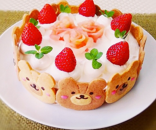 a cake with strawberries and teddy bears on it is sitting on a white plate