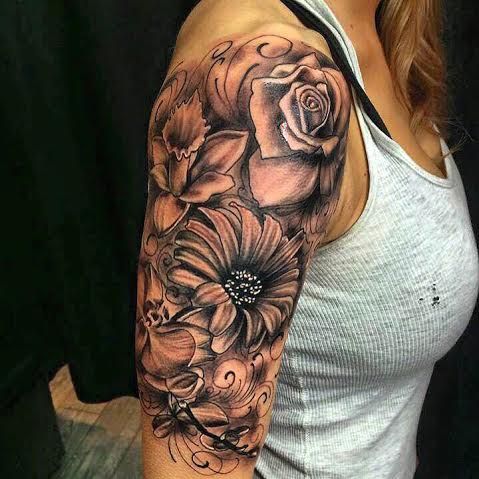 a woman's half sleeve with flowers on her left arm and an open shoulder