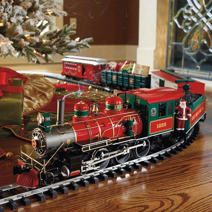 a toy train is on the tracks next to a christmas tree and presents in front of it