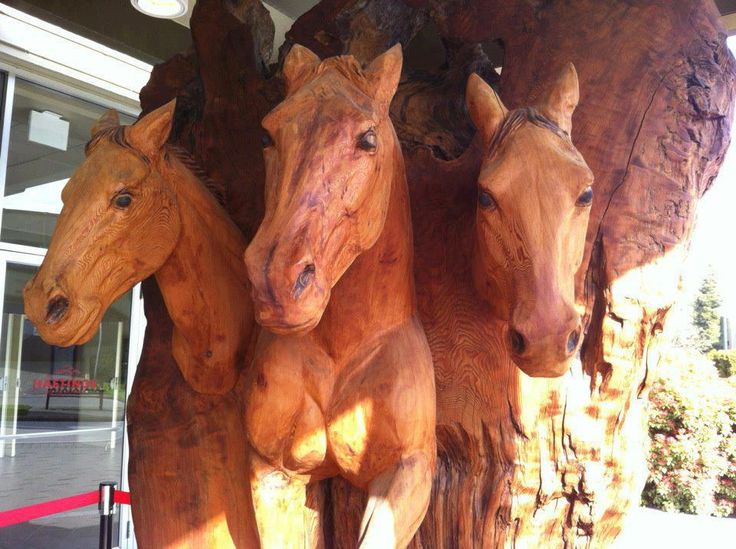 three wooden horses standing next to each other