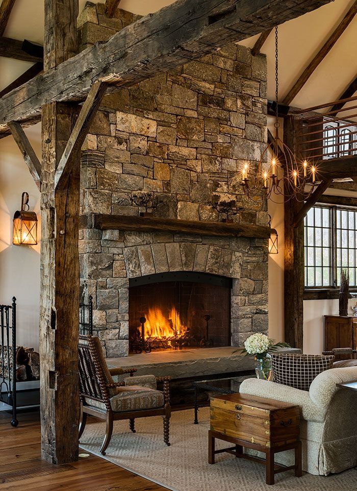 a stone fireplace in the middle of a living room