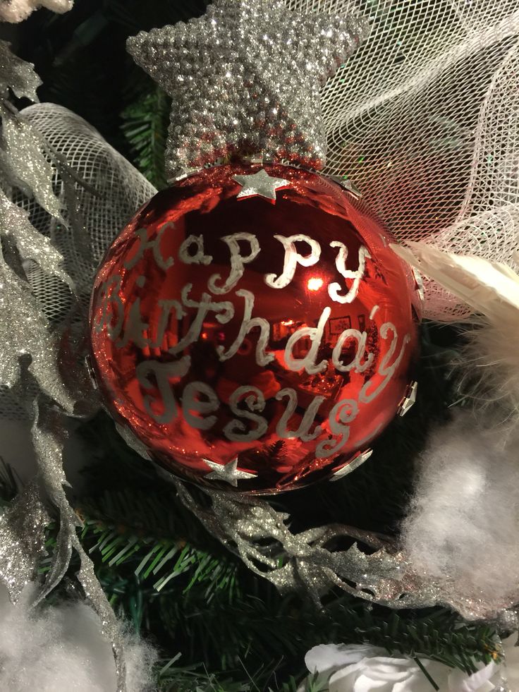 a red ornament hanging from the side of a christmas tree with happy birthday message on it