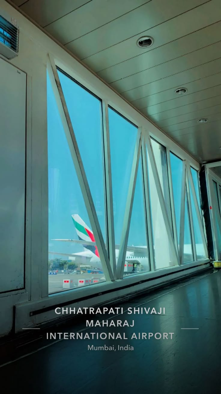 an airplane is seen through the windows of this airport terminal building in mumbai, india