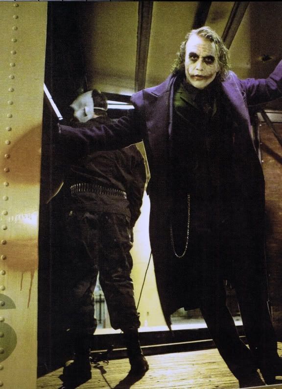 a man dressed as the joker standing next to another man