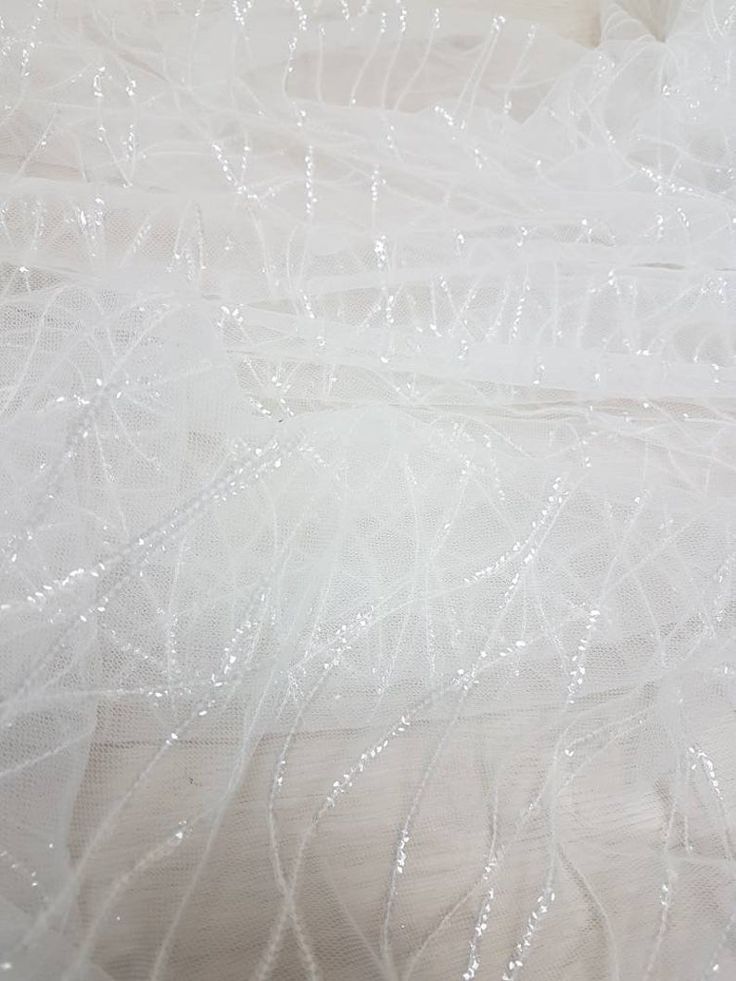 the fabric is white and has small beads on it