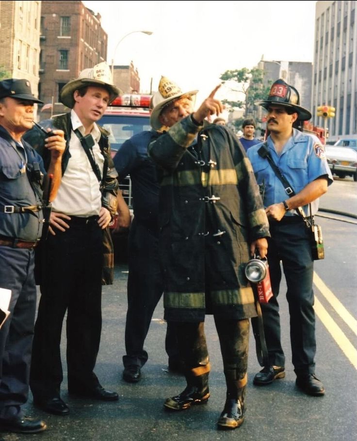 a group of men standing next to each other on the side of a city street