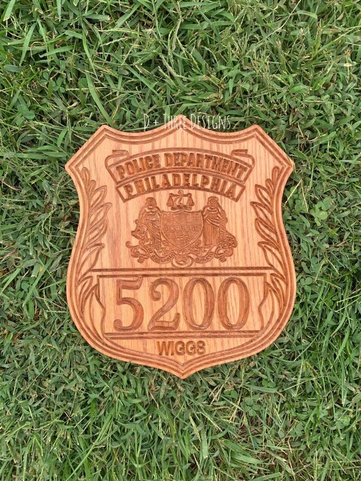 a wooden plaque with the name and image of a police officer on it in grass